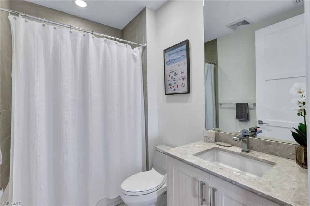 1035 3rd Avenue South, Unit 514 Naples, FL 34102 - Photo 20 of 35 a bathroom with a granite countertop sink and a mirror