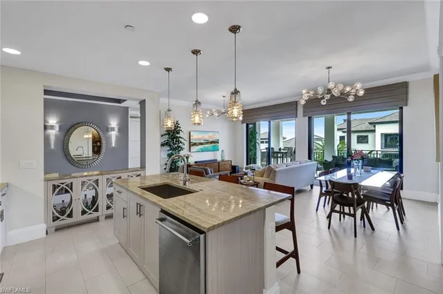 a view of a dining room and livingroom with furniture wooden floor a chandelier