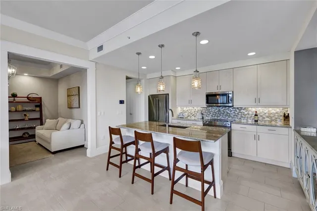 a kitchen with stainless steel appliances kitchen island granite countertop a sink and cabinets