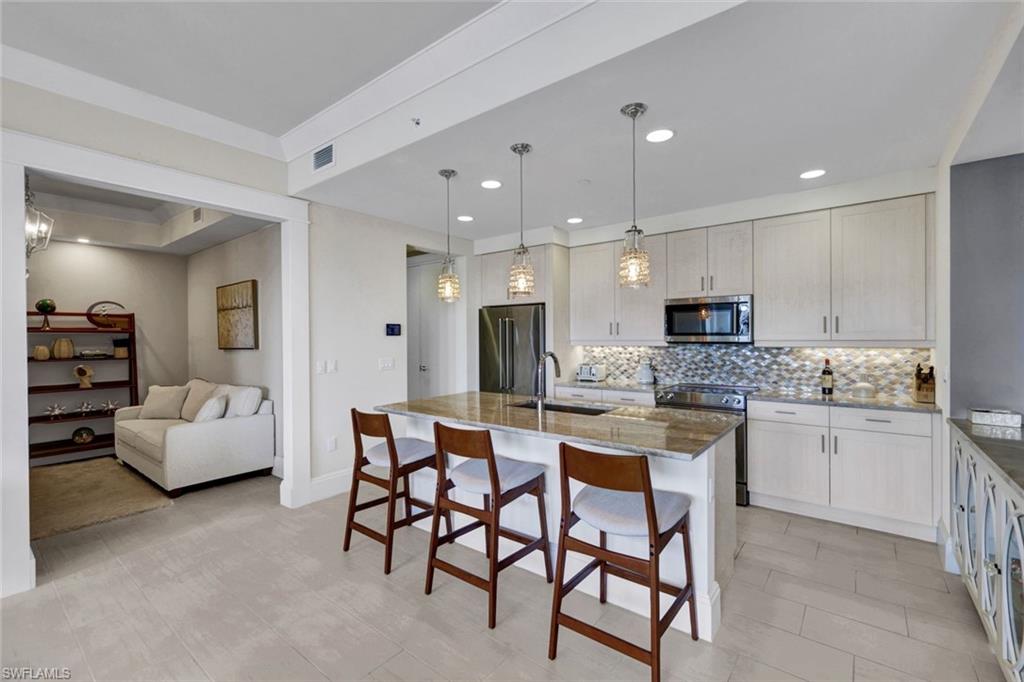 1035 3rd Avenue South, Unit 514 Naples, FL 34102 - Photo 8 of 35 a kitchen with stainless steel appliances kitchen island granite countertop a sink and cabinets