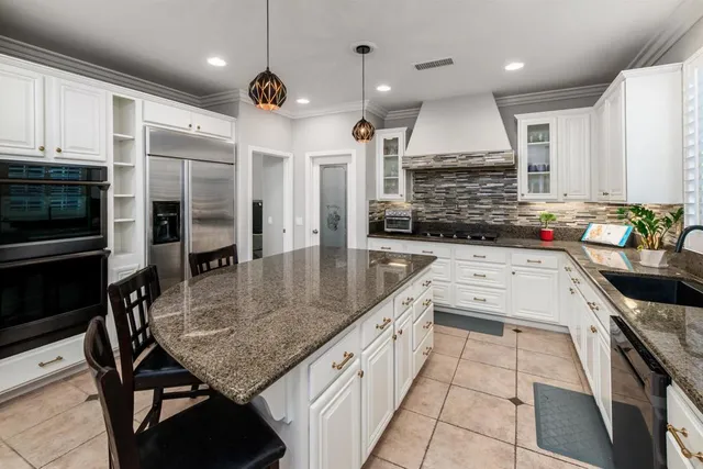 a kitchen with stainless steel appliances granite countertop a sink a stove and a wooden cabinets