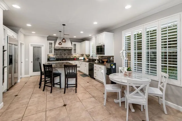 a kitchen with kitchen island granite countertop wooden cabinets and a dining table
