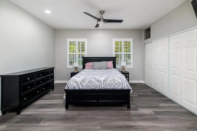 a bedroom with a bed window and a ceiling fan