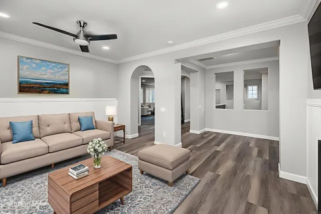 a living room with furniture a rug and a ceiling fan