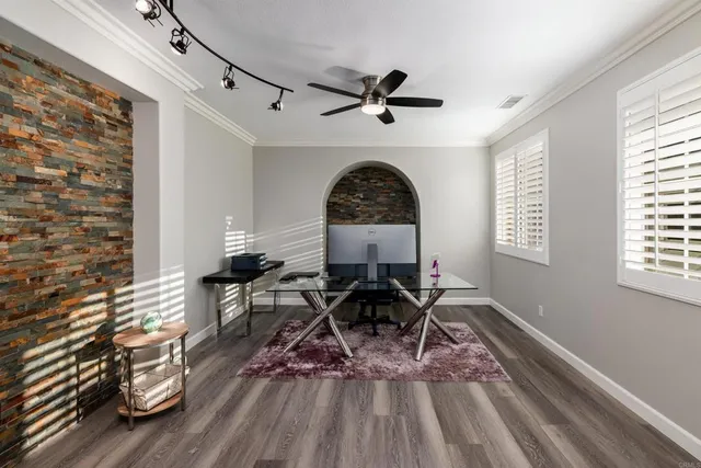 a view of a livingroom with furniture wooden floor front door and windows