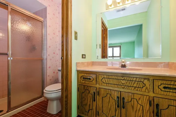 a bathroom with a sink a toilet and shower