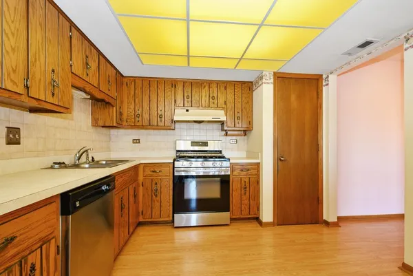 a kitchen with stainless steel appliances granite countertop a sink a stove and a refrigerator