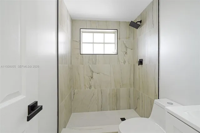 a bathroom with a bathtub shower and toilet