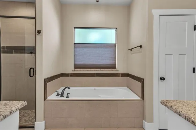 a spacious bathroom with a granite countertop sink a mirror and shower