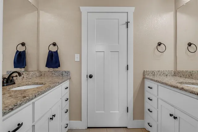 a kitchen with granite countertop white cabinets and sink