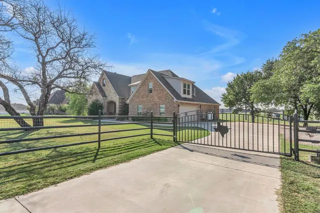 a view of a house with a yard and large trees
