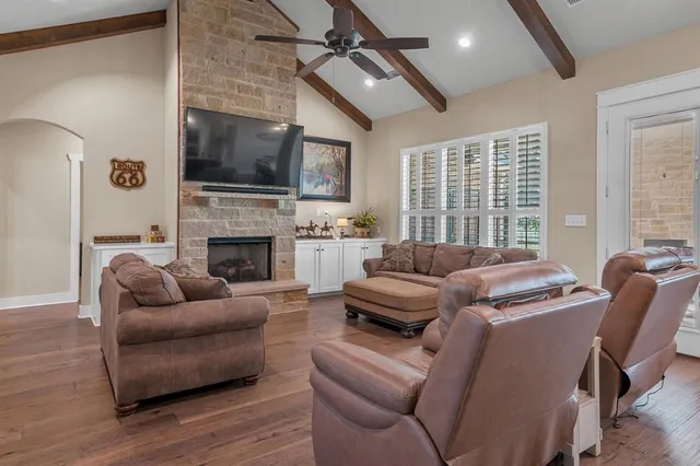 a living room with furniture a flat screen tv and a fireplace