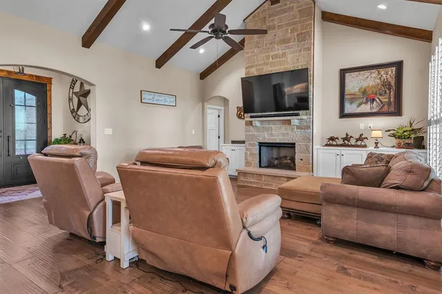a living room with furniture kitchen view and a large window