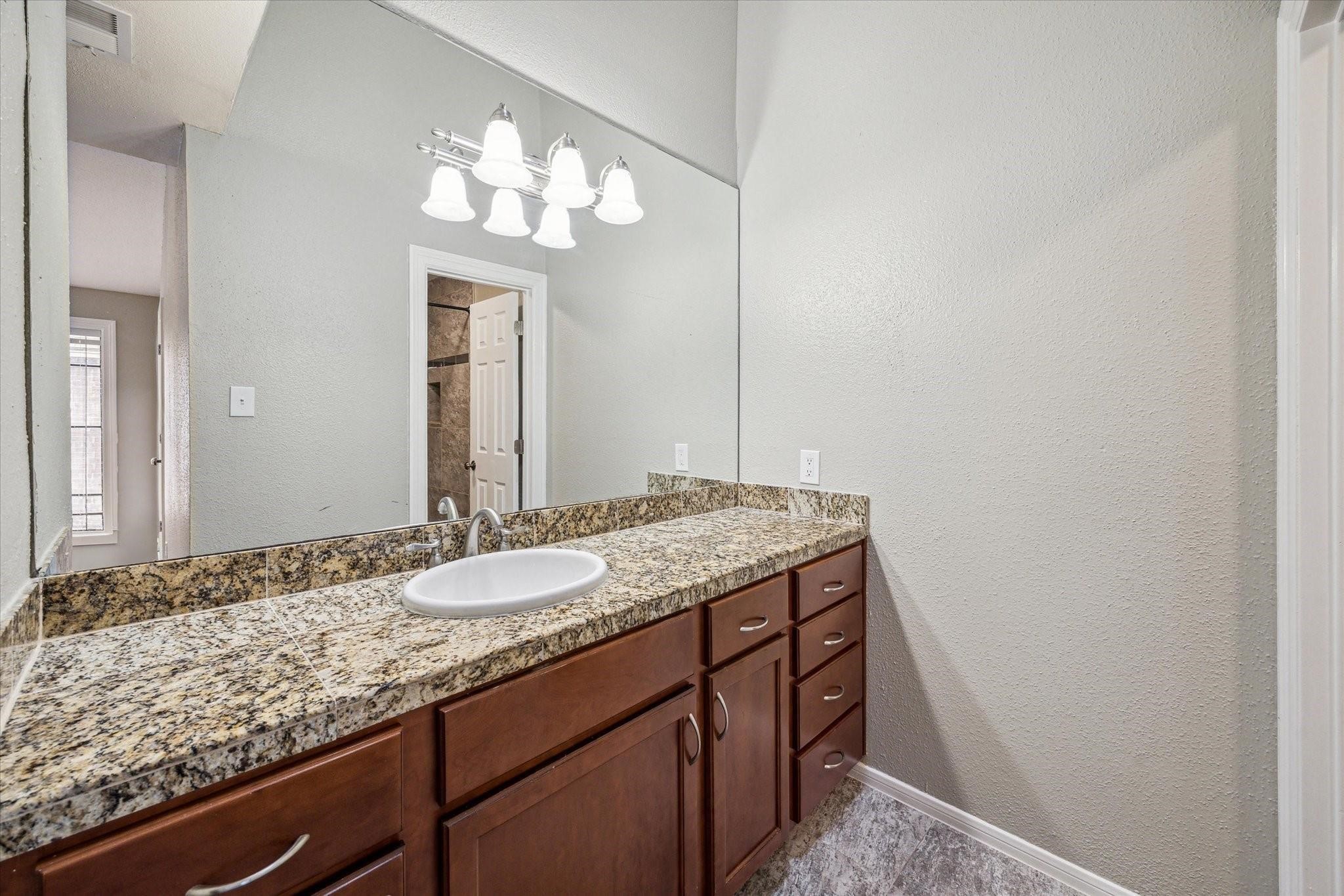 2211 South Kirkwood Road, Unit 9 Houston, TX 77077 - Photo 13 of 16 a bathroom with a granite countertop sink a large mirror and a shower