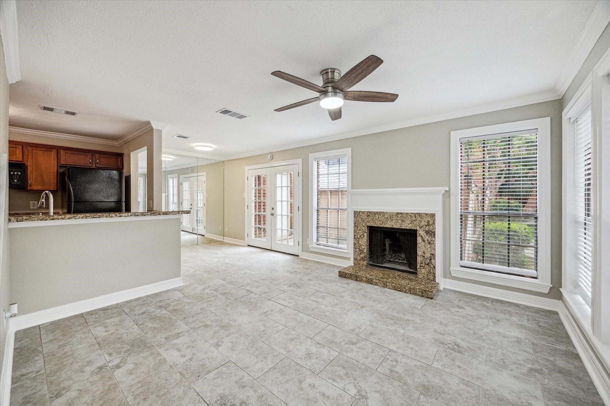 2211 South Kirkwood Road, Unit 9 Houston, TX 77077 - Photo 4 of 16 a view of a livingroom with a fireplace a ceiling fan and windows
