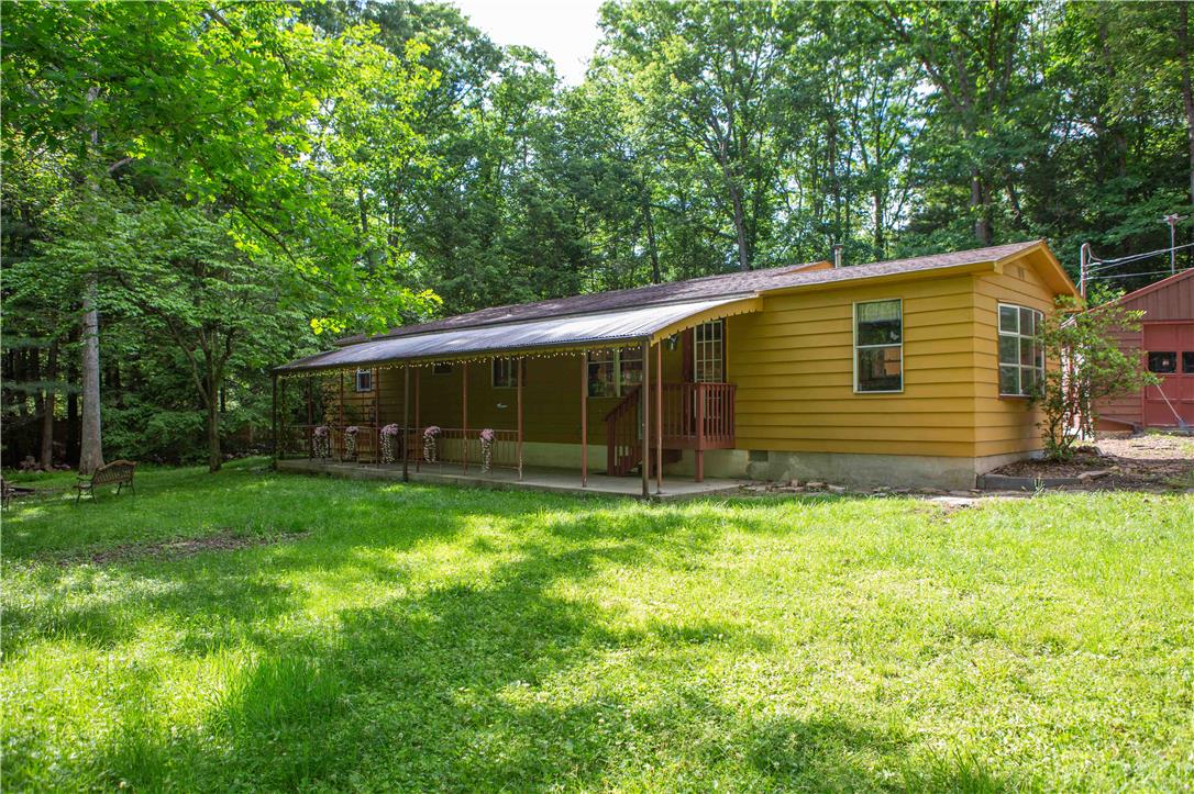 8 Cross Rds Drive Jim Thorpe, PA 18229 - Photo 2 of 32 A quaint ranch-style home with a welcoming covered porch, nestled amongst a verdant treeline.