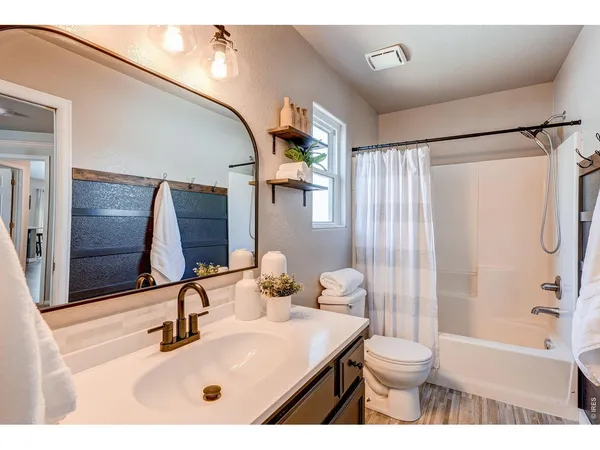 a bathroom with a sink toilet a mirror and shower