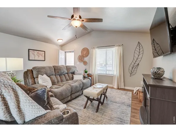 a living room with furniture a chandelier and a flat screen tv