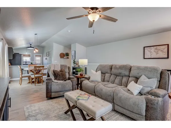 a living room with furniture a ceiling fan and a rug