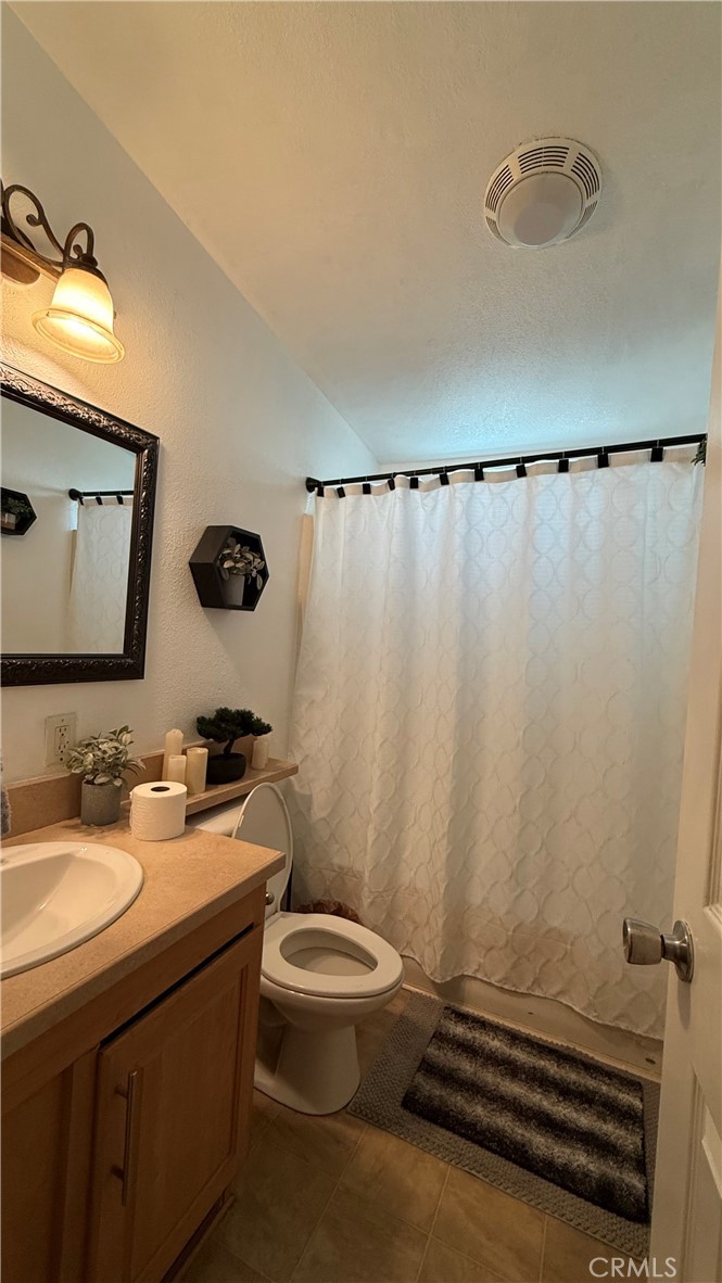 2250 West Mill Street, Unit 70 Colton, CA 92324 - Photo 12 of 14 a bathroom with a sink a toilet a mirror and shower curtain