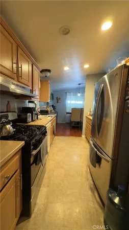 a kitchen with stainless steel appliances granite countertop a stove a refrigerator and a sink