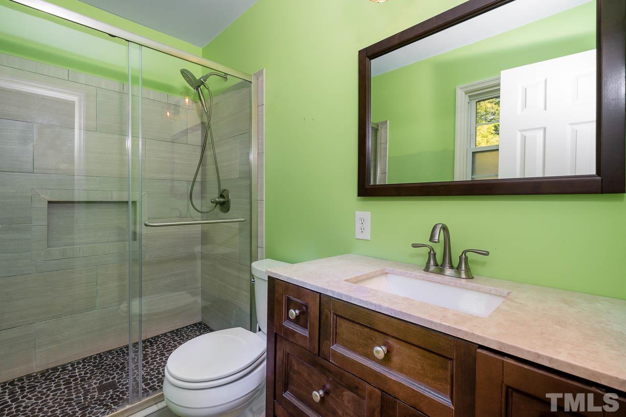 7405 Mine Valley Road Raleigh, NC 27615 - Photo 23 of 24 a bathroom with a sink a toilet and shower