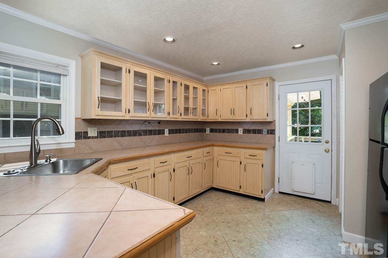 7405 Mine Valley Road Raleigh, NC 27615 - Photo 10 of 24 a large kitchen with granite countertop a sink and cabinets