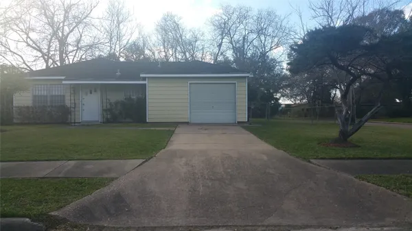 a view of a white house with a big yard and large trees