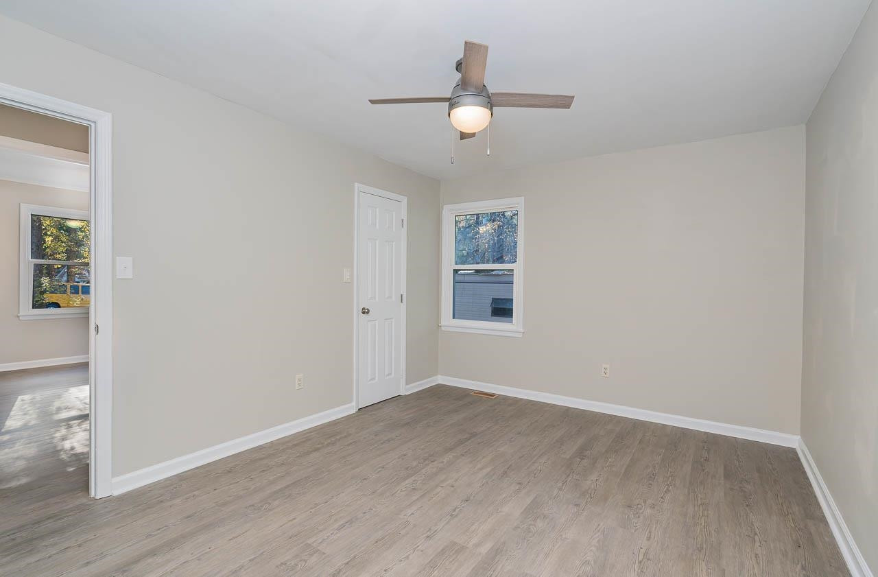 5917 Meadowlark Lane Raleigh, NC 27610 - Photo 14 of 24 an empty room with wooden floor chandelier fan and windows