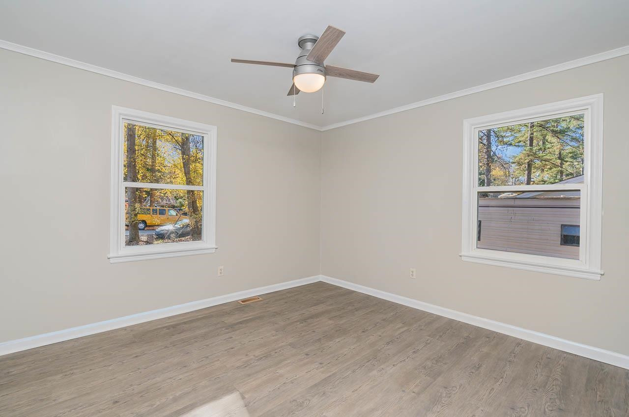 5917 Meadowlark Lane Raleigh, NC 27610 - Photo 16 of 24 a view of an empty room with a window and wooden floor