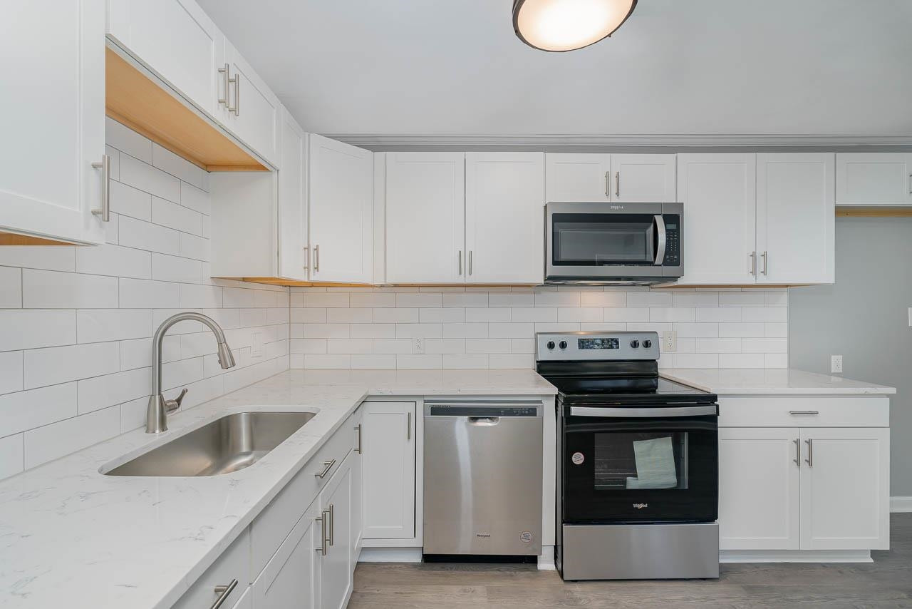 5917 Meadowlark Lane Raleigh, NC 27610 - Photo 2 of 24 a kitchen with stainless steel appliances a stove a sink a stove and a microwave
