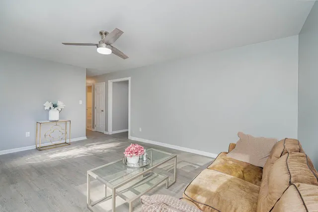 a kitchen with a refrigerator a sink dishwasher a stove and white cabinets with wooden floor