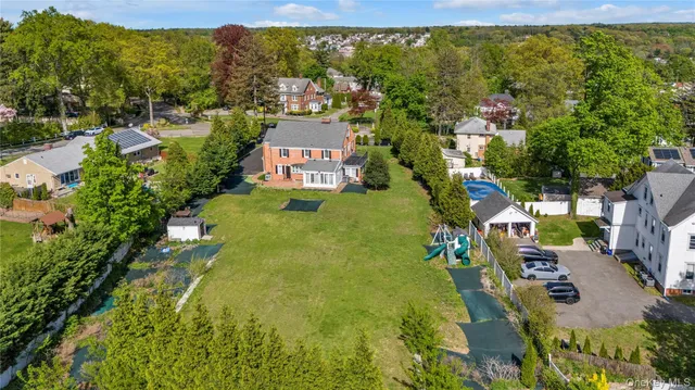 an aerial view of residential houses with outdoor space and trees