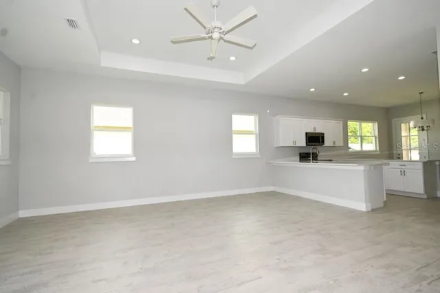 an empty room with windows and ceiling fan