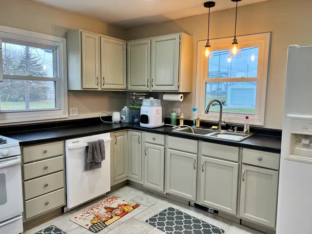 a kitchen with stainless steel appliances granite countertop a sink a stove and cabinets