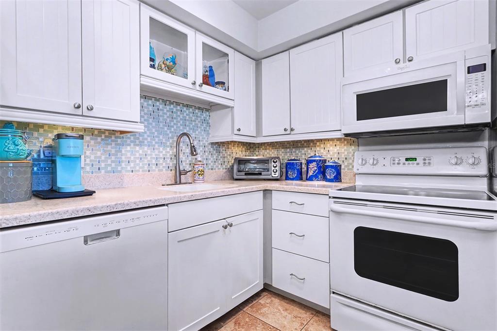 17400 Gulf Boulevard, Unit H2 Redington Shores, FL 33708 - Photo 14 of 36 a kitchen with granite countertop white cabinets stainless steel appliances and sink