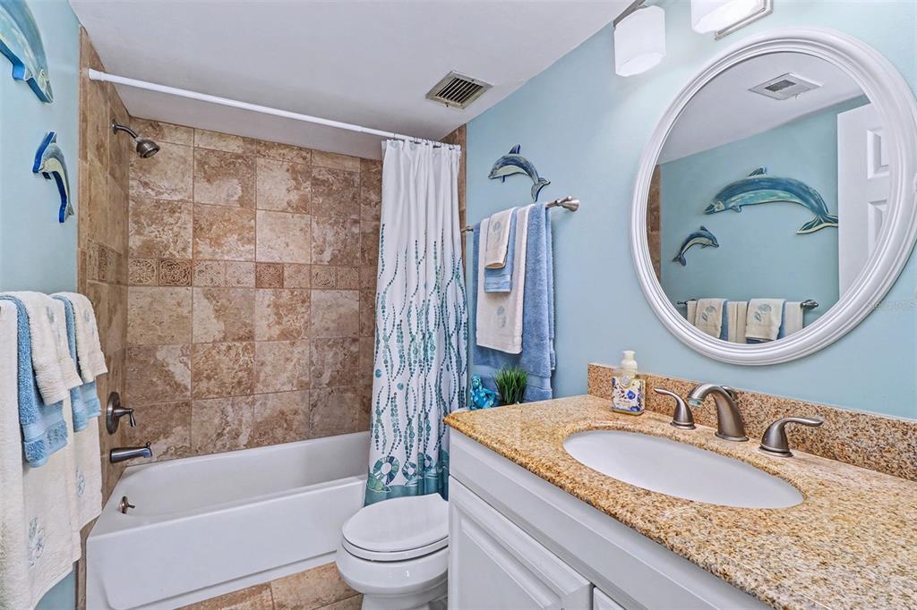 17400 Gulf Boulevard, Unit H2 Redington Shores, FL 33708 - Photo 18 of 36 a bathroom with a granite countertop sink a toilet and a mirror