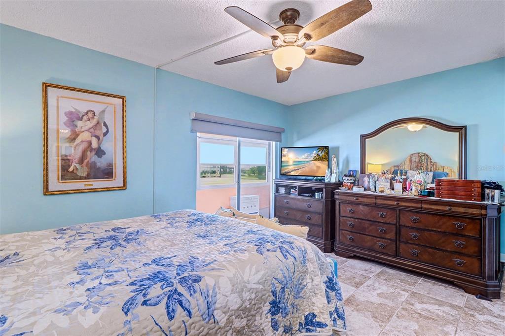 17400 Gulf Boulevard, Unit H2 Redington Shores, FL 33708 - Photo 20 of 36 a bedroom with a bed and a chandelier on dresser