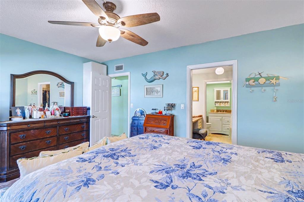 17400 Gulf Boulevard, Unit H2 Redington Shores, FL 33708 - Photo 21 of 36 a bedroom with a bed and a dresser with mirror