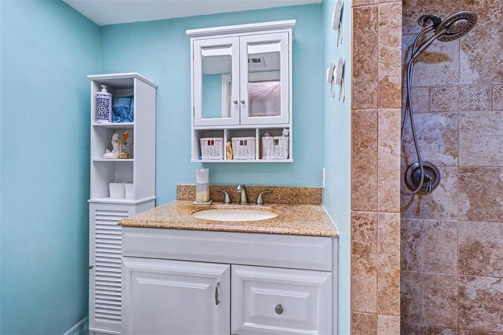 17400 Gulf Boulevard, Unit H2 Redington Shores, FL 33708 - Photo 23 of 36 a bathroom with a granite countertop sink a mirror and shower