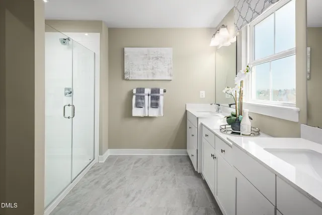 a bathroom with a double vanity sink mirror and next to a window
