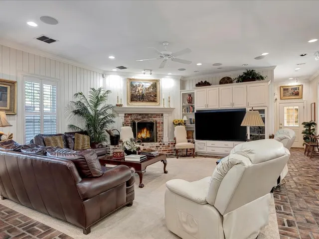 a living room with furniture a flat screen tv and a fireplace