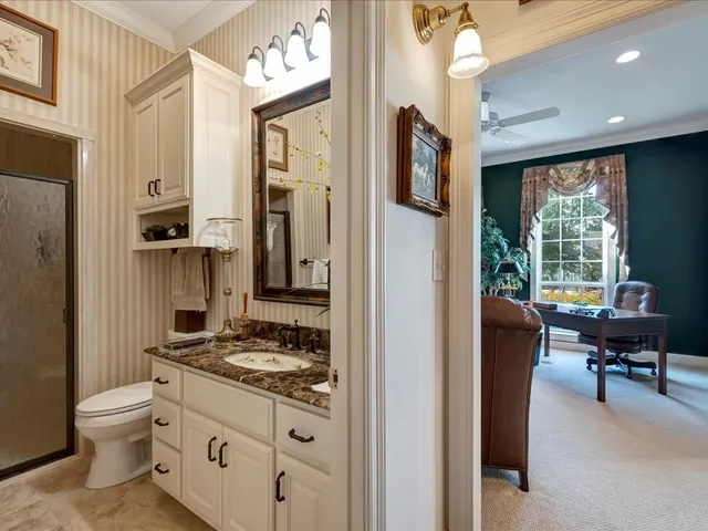 a bathroom with a granite countertop sink mirror vanity and toilet