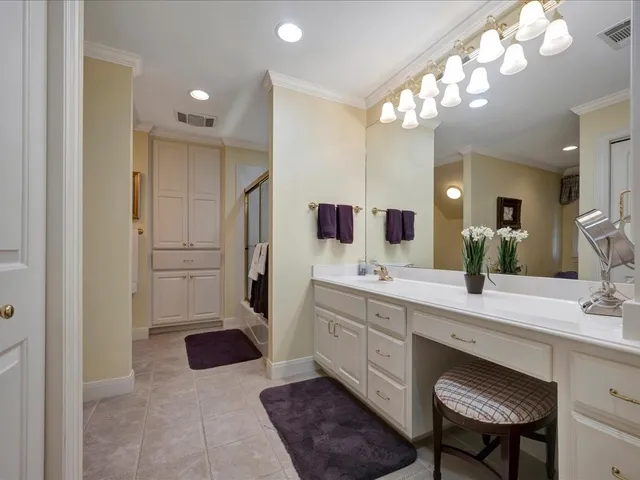 a spacious bathroom with a double vanity sink a mirror and a shower