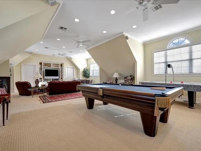 a living room with furniture and a pool table