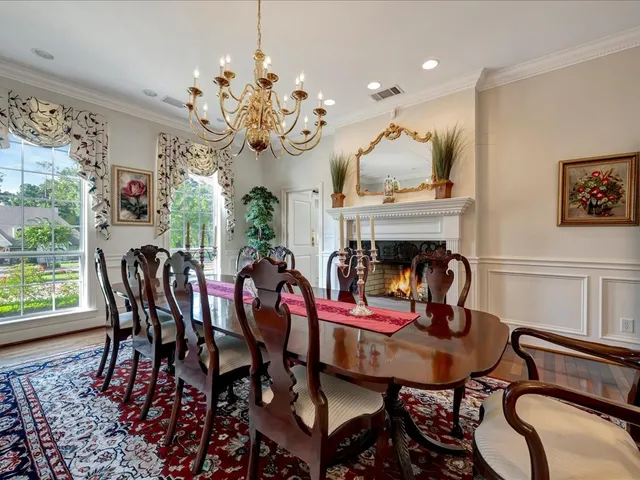 a view of a dining room with furniture a chandelier and a window