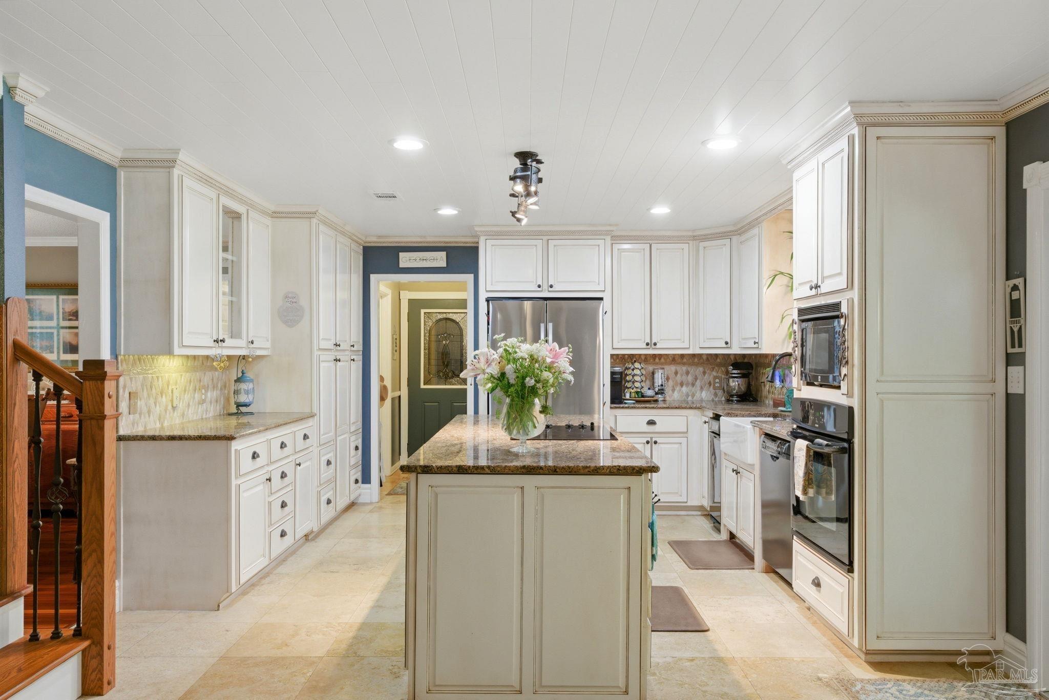 6930 Summit Way Milton, FL 32570 - Photo 16 of 71 a kitchen with kitchen island white cabinets and refrigerator