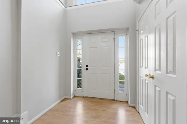 a view of a hallway with wooden floor and closet area