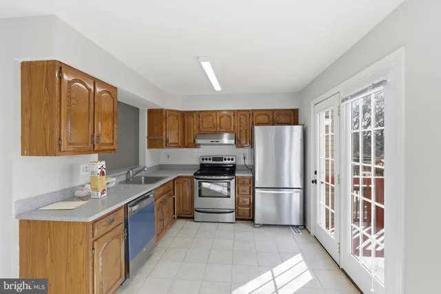 a kitchen with stainless steel appliances granite countertop a refrigerator and a sink