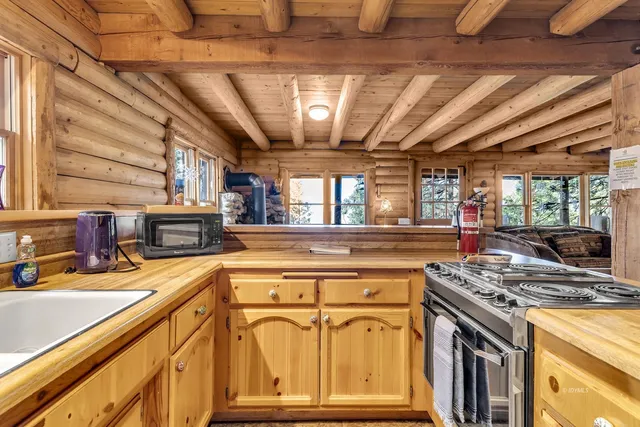 a kitchen with stainless steel appliances a table chairs and a wooden cabinets